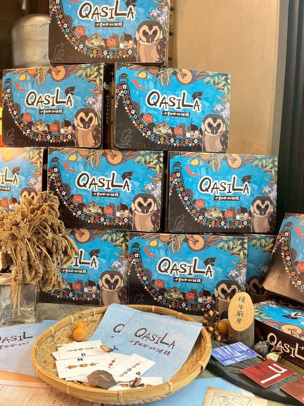 《Qasila!卡里布安的謎題》實景解謎遊戲盒 一位日本廚師森本清志,為了尋找贏得料理大賞的秘密武器,絞盡腦汁。意外在阿公遺物中找到殘存的神祕香料鹽,香料鹽的香氣喚醒清志的童年記憶,也許這個神祕的香氣就是他突破瓶頸的關鍵。於是他翻遍阿公的遺物,發現線索指向阿公的出生地——台灣的望鄉部落(現稱卡里布安)。